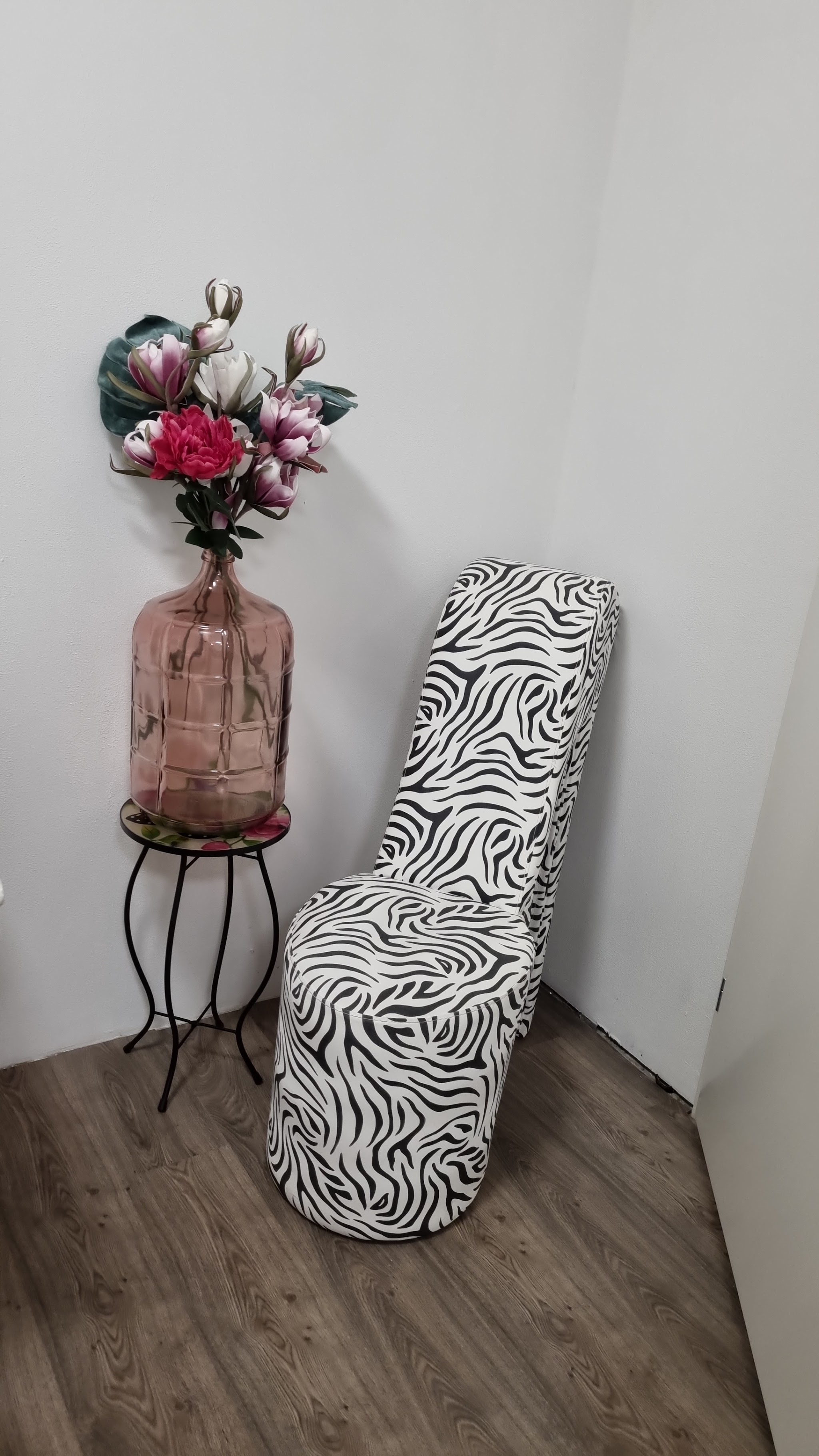 Hoek van de studio met een zebrastoel en een vaas met bloemen